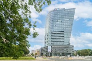 Un edificio alto de cristal con un cartel. en Apartament w Hanza Tower, en Szczecin