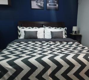 マンダウエ・シティにあるLaraHome City Livingの青いベッドルーム(大型ベッド1台、枕2つ付)