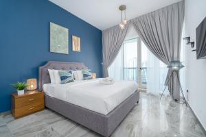 - une chambre bleue avec un lit et un mur bleu dans l'établissement Dubai Marina Stunning Huge 4 Bedroom Apts Near JBR Gym Pool Parking, à Dubaï