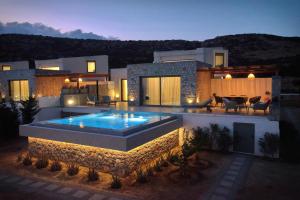 a house with a swimming pool in front of it at Aros Luxury Villas in Karpathos Town