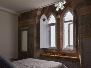 a bedroom with three windows in a brick wall at Waterwynch in Criccieth