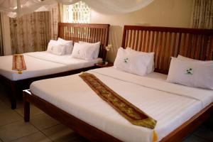 Postel nebo postele na pokoji v ubytování Entebbe Palm Hotel + 37 fotografií