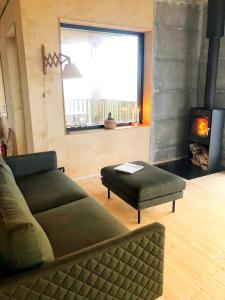a living room with a couch and a fireplace at Beautiful cottage with Mountain View in Fludir