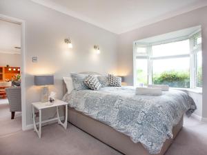 a bedroom with a bed and a window at Leighwood Cottage in Paignton