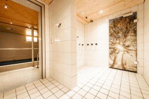 a bathroom with a shower with a tree mural at Ferienhotel Almajur in Mittelberg