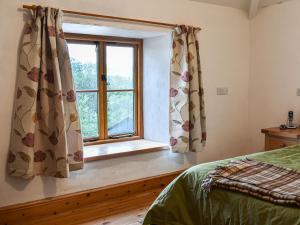 a bedroom with a bed and a window at Nant Y Crogwyn in Penmachno