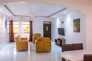 a living room with chairs and a flat screen tv at Leomilo Holidays in Diani Beach
