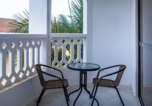 a table and two chairs on a balcony at Leomilo Holidays in Diani Beach