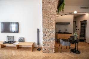 ceglany filar w pokoju ze stołem i krzesłami w obiekcie S1 Luxury Suites and Rooms w Trieście