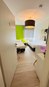una camera con due letti e una camera con pareti verdi di smart&beautiful Guesthouse a Nordkirchen