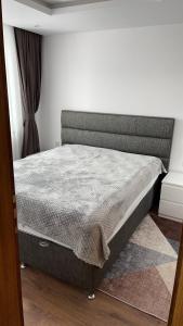 a bed in a bedroom with a gray mattress at ORION APARTMENTS in Chepelare