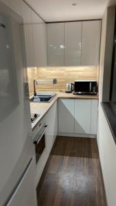 a small kitchen with white cabinets and a sink at ORION APARTMENTS in Chepelare