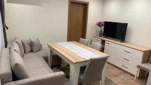 a living room with a table and a couch at ORION APARTMENTS in Chepelare