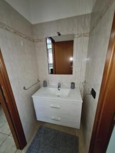 uma casa de banho com um lavatório branco e um espelho. em La casa di Ida Intero appartamento em Vigevano