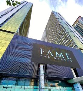 een hoog gebouw met een bord ervoor bij One Bedroom Condo Unit Fame Residences in Manilla