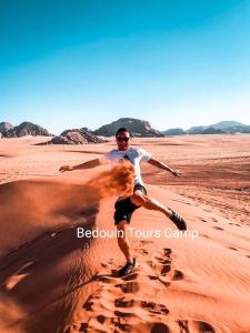 a man in the desert with a baseball bat at Bedouin Tours Camp in Wadi Rum