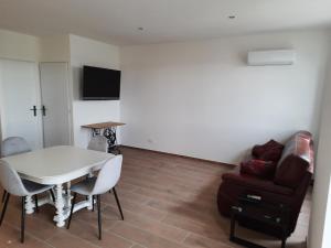 ein Wohnzimmer mit einem weißen Tisch und einem Sofa in der Unterkunft LA CLEF DES CHAMPS GITE PERRINE in Brouckerque