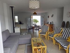 LʼHerbaudièreにあるMaison de vacances Ile de noirmoutierのソファと椅子とテーブルのあるリビングルーム