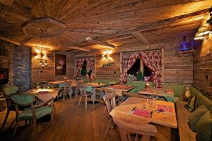 ein Restaurant mit Holzwänden, Tischen und Stühlen in der Unterkunft Assietta in Sauze dʼOulx