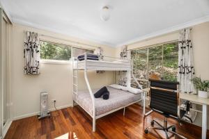 a bedroom with a bunk bed and a desk at Aqua Vista in Smiths Lake