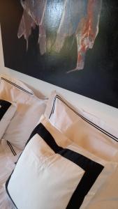 a bed with black and white sheets and a painting at Greek Island bungalow in Samos set in beautiful nature in Samos