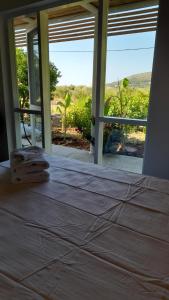 a bed in a room with a large window at Greek Island bungalow in Samos set in beautiful nature in Samos