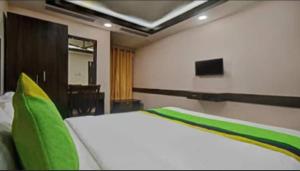 a bedroom with a large bed with green pillows at Hotel R DELUXE "Couple Friendly Vaccinated Staff" in New Delhi
