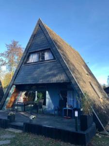 une maison au toit de chaume avec une terrasse couverte dans l'établissement Ferienhaus Familie Mischkies, à Damp