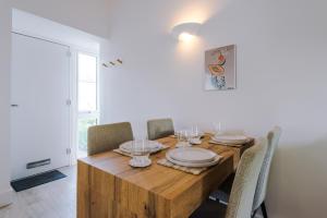 a dining room table with chairs and a wooden table with glasses at Wild Drive Chester - Stunning cottage in CH1 with Double Parking in Chester