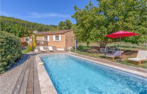 une piscine avec un parasol rouge et des chaises ainsi qu'une maison dans l'établissement Nice Home In Salernes With Wifi, à Salernes
