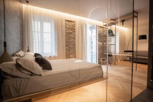 sypialnia z łóżkiem i szklaną ścianą w obiekcie S1 Luxury Suites and Rooms w Trieście