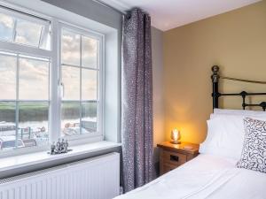 a bedroom with a bed and a window at Riverside Cottage in Reedham