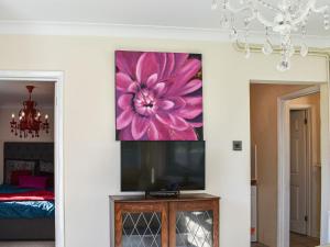 uma sala de estar com uma grande pintura de flores cor-de-rosa na parede em Ace Lodge em Hoddesdon
