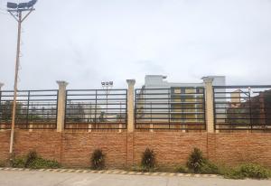 eine Backsteinmauer mit einem Gebäude im Hintergrund in der Unterkunft LaraHome City Living in Mandaue City