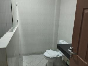 ラブハン・バジョにあるPalm bajo hotelのトイレと洗面台を備えた白いバスルーム