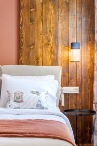 a bedroom with a bed with a wooden wall at Paeonia Arachova in Arachova