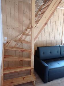 a living room with a blue couch and wooden stairs at apartamentyDvorskie in Nowy Sącz