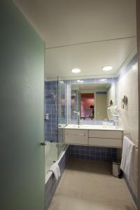 a bathroom with a shower and a sink and a mirror at Royal Son Bou Family Club in Son Bou