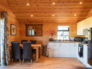 a kitchen with a table and chairs in a cabin at Cabin Hideaways, Glenfyne - Uk38362 in Mattishall
