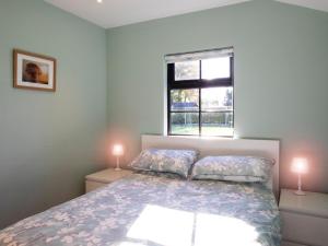 1 dormitorio con 1 cama con 2 lámparas y una ventana en Cabin Hideaways, Glenfyne - Uk38362, en Mattishall