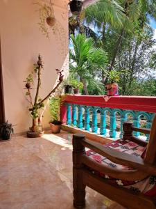 a room with a balcony with potted plants and a bench at Bageecha B&B- Vaayu in Alibaug