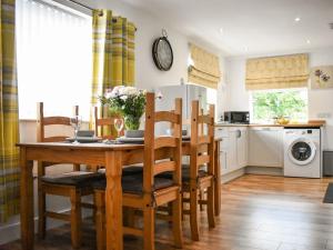 a kitchen and dining room with a wooden table and chairs at Bumblebee Lodge in Staithes