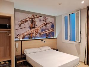 a bedroom with a bed and a painting of a ship at Hostal Las Flores Ramblas in Barcelona