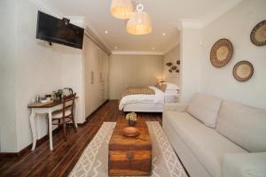 uma sala de estar com um sofá e uma cama em Viewpoint Estate Guest House em Haenertsburg