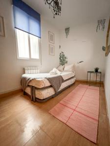 a bedroom with a bed and a red rug at El domicilio de Fernando Garrido in Madrid
