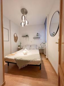 a bedroom with a bed and a round mirror at El domicilio de Fernando Garrido in Madrid