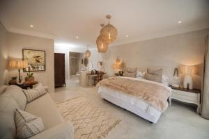 um quarto com uma cama grande e uma sala de estar em Viewpoint Estate Guest House em Haenertsburg