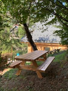 a wooden picnic table sitting under a tree at Chalet La Felize in Oz