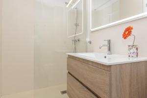 a bathroom with a sink and a mirror at Apartment Almirall in Puerto Pollensa By homevillas360 in Pollença