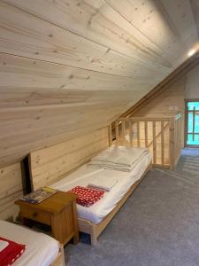 a wooden room with a bed in a attic at Chalet La Felize in Oz